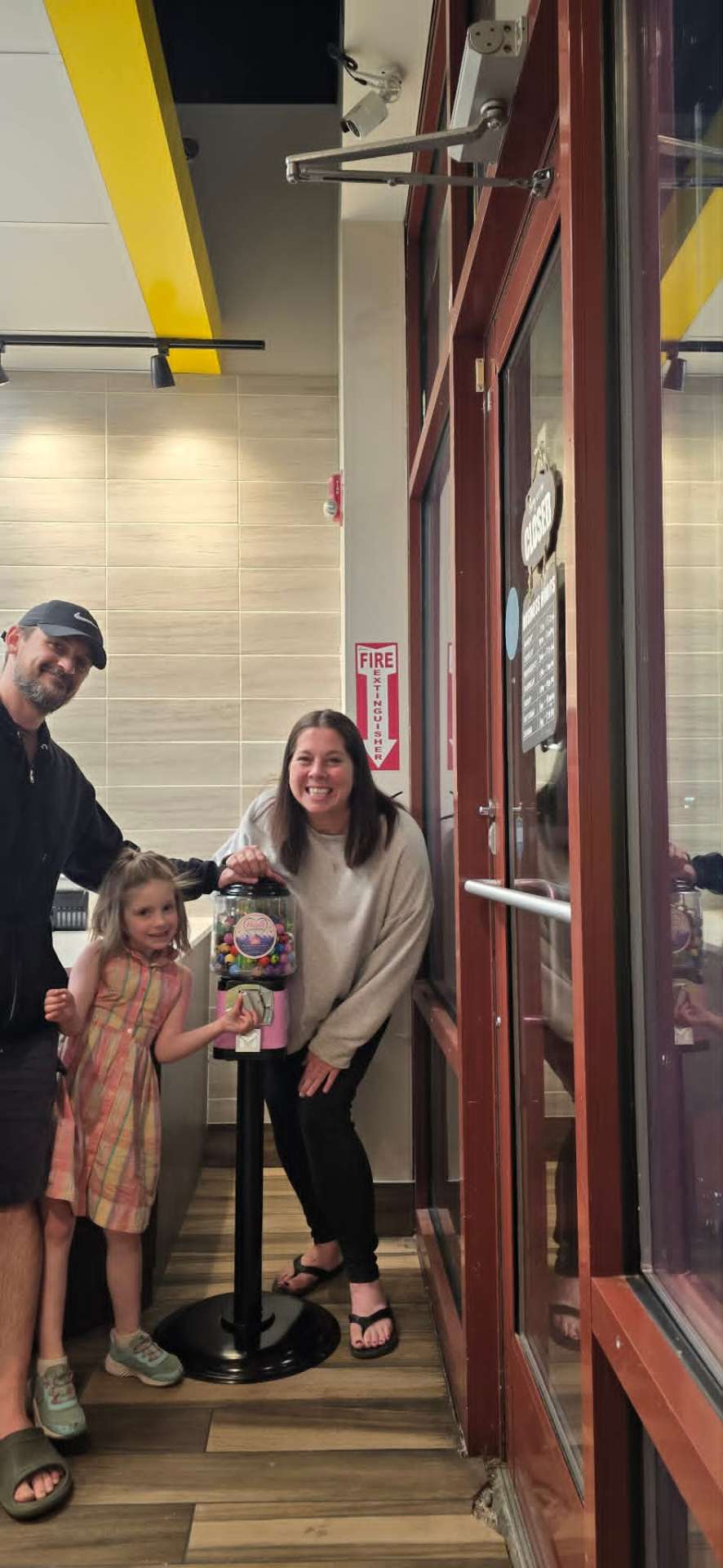 The Hazel's Treasures family standing together with their first bouncy ball vending machine in a local Colorado business